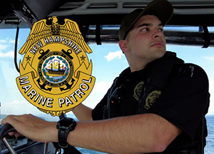 A New Hampshire State Police Marine Patrol officer next to the agency’s official seal.